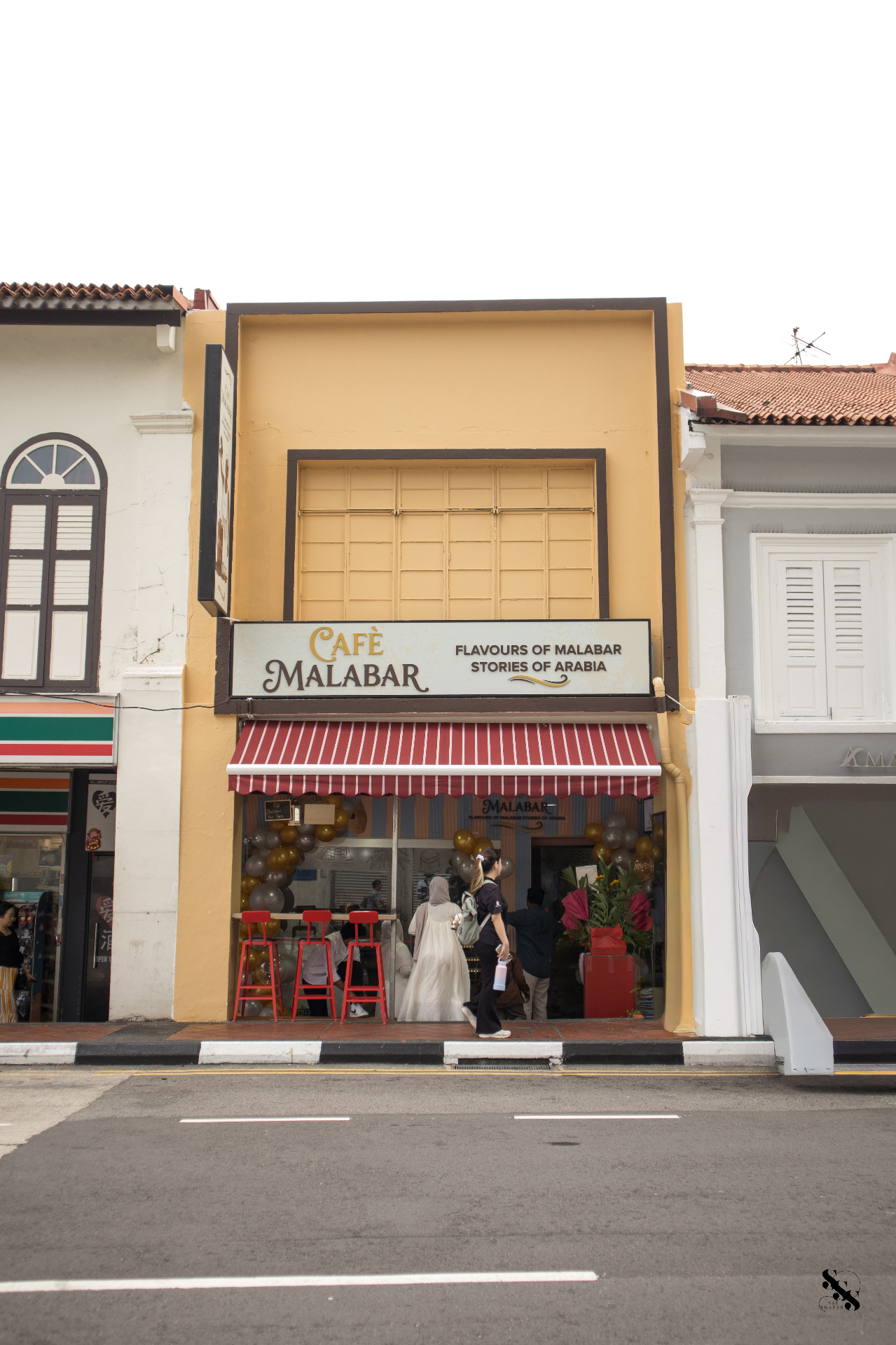 Café Malabar shopfront — a yellow shophouse with red-striped awning at 142 Arab Street, Singapore